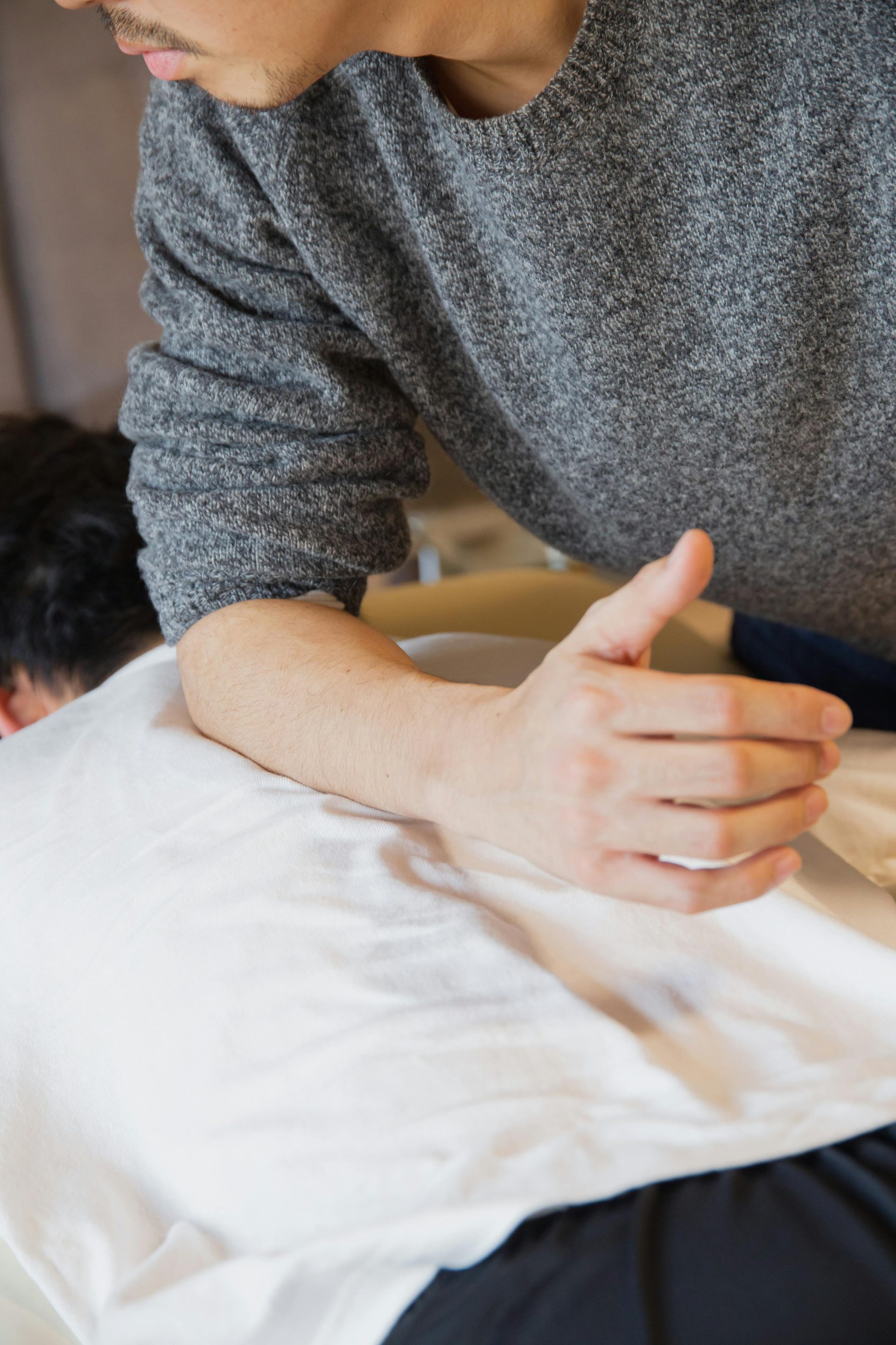 Eine Massagetherapeutin führt eine therapeutische Sitzung durch, die sich auf Muskelentspannung und Wohlbefinden konzentriert.